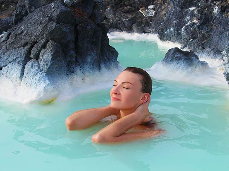 Young beautiful woman bathing in the blue lagoon